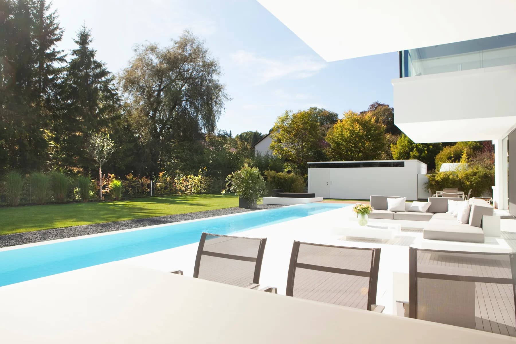A bright modern home with a pool and landscaped yard